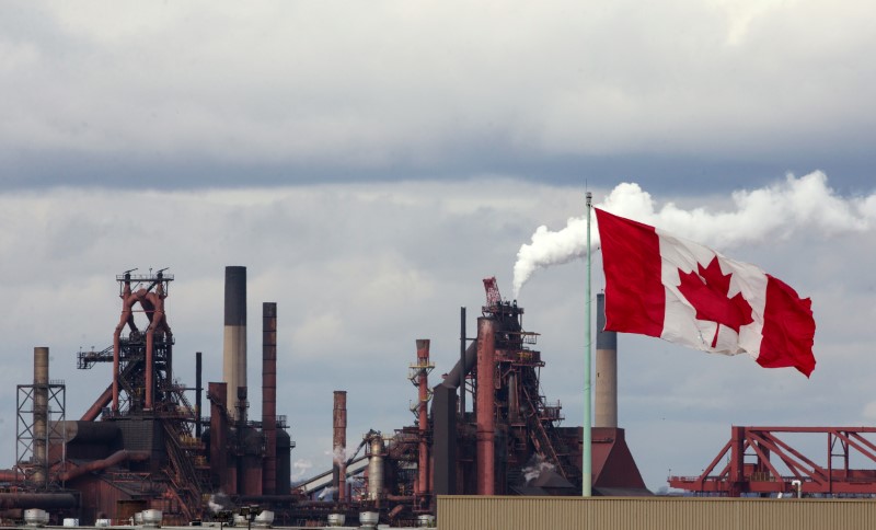 © Reuters. FILE PHOTO: A Canadian flag flies above another industry site with  ArcelorMittal Dofasco in the background in Hamilton