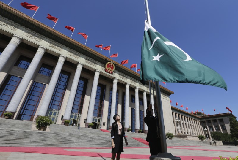 © Reuters. FILE PHOTO: A staff member raises Pakistan's flag in front of the Great Hall of the People ahead of a welcome ceremony for Pakistan's Prime Minister in Beijing