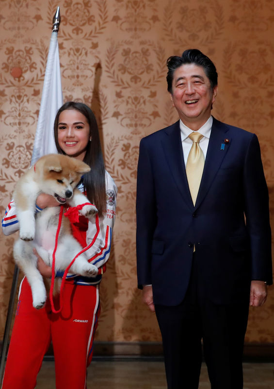 © Reuters. رئيس وزراء اليابان يشارك في إهداء بطلة أولمبية روسية كلبا