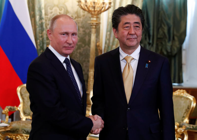 © Reuters. Russian President Putin shakes hands with Japanese PM Abe during their meeting at the Kremlin in Moscow