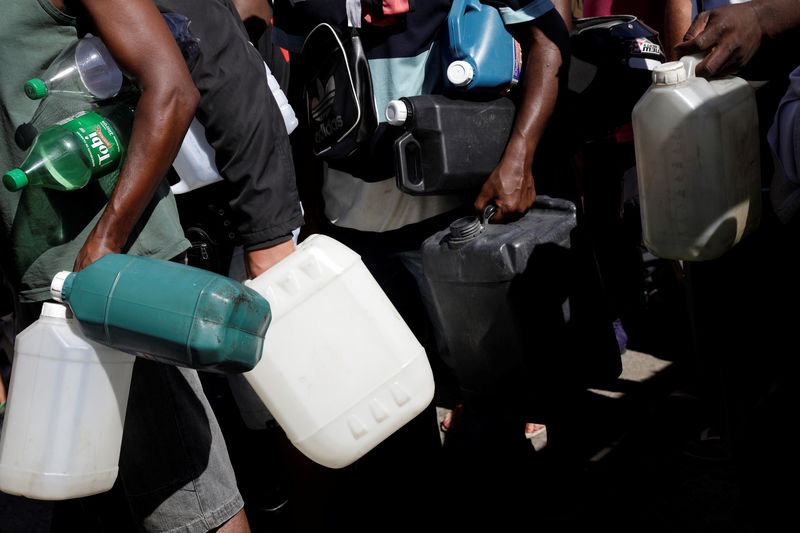 © Reuters. People wait in line to fill canisters with gasoline at a gas station in Rio de Janeiro