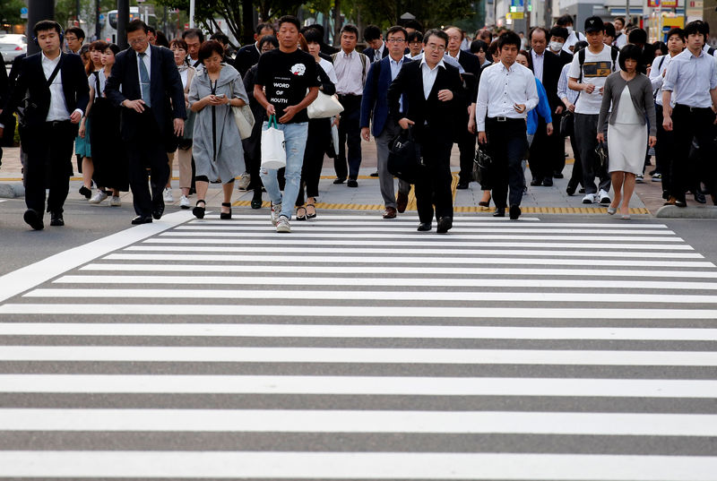 © Reuters. Pedestrians make their way in a business district in Tokyo