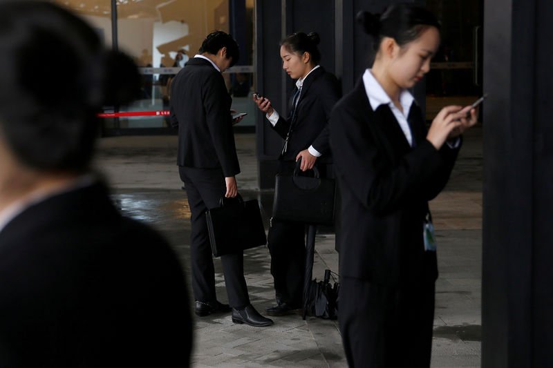 © Reuters. FILE PHOTO: People check their phones during the third annual World Internet Conference in Wuzhen town of Jiaxing