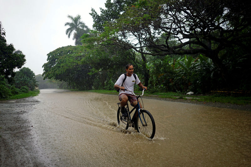 © Reuters. Homem anda de bicicleta durante tempestade em Bahia Honda, Cuba