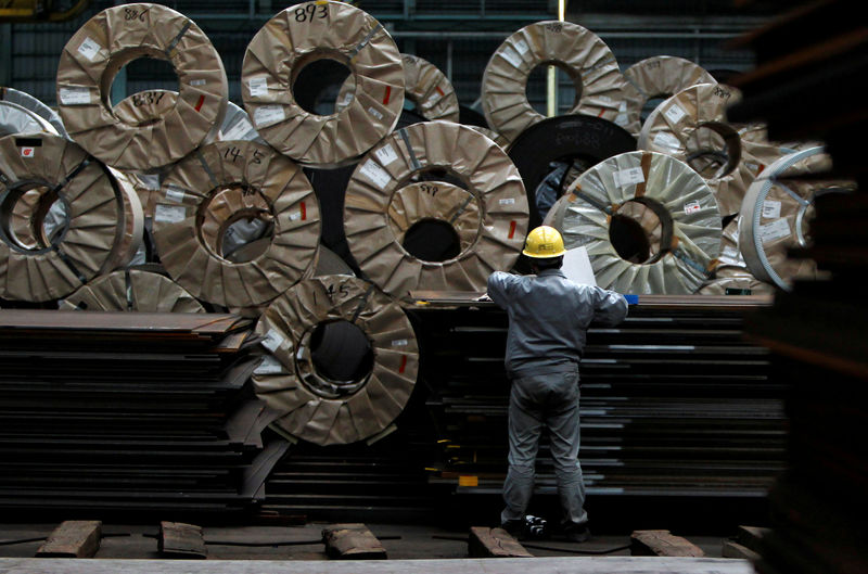 © Reuters. FILE PHOTO - A worker checks steel coils and steel sheets at a distribution warehouse in Urayasu, east of Tokyo