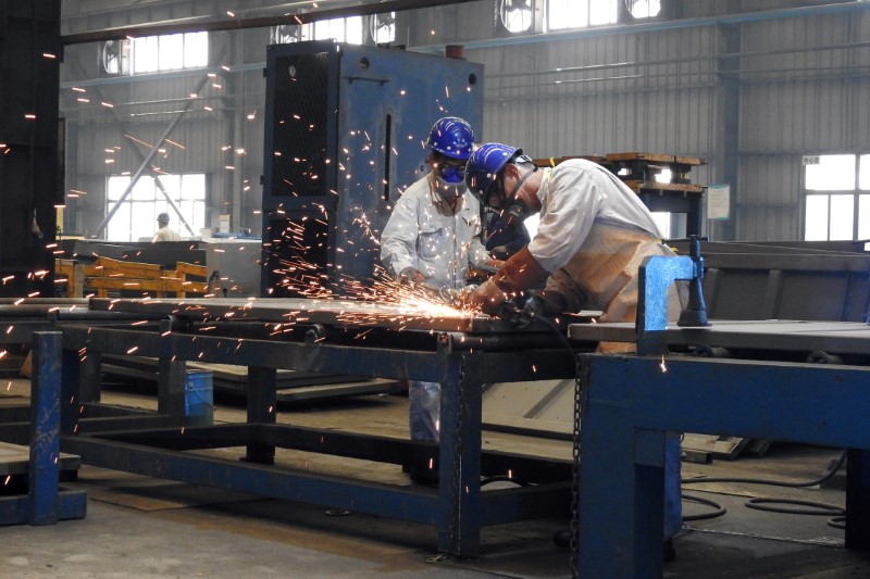 © Reuters. Workers weld shipping container components at a container manufacturing company in Lianyungang