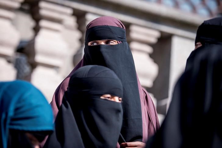 © Reuters. Women in niqab are pictured after the Danish Parliament banned the wearing of face veils in public, at Christiansborg Palace in Copenhagen