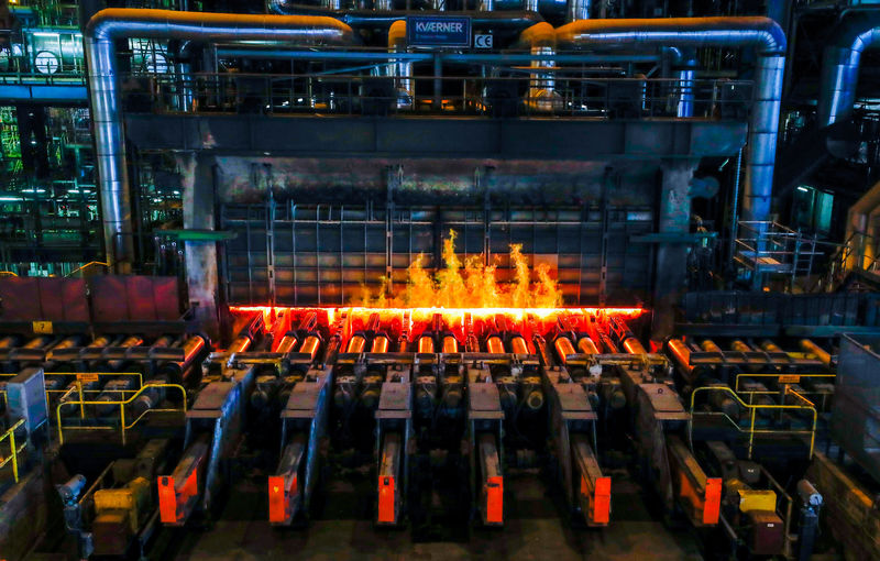 © Reuters. FILE PHOTO: A red-hot steel plate passes through a press at the ArcelorMittal steel plant in Ghent