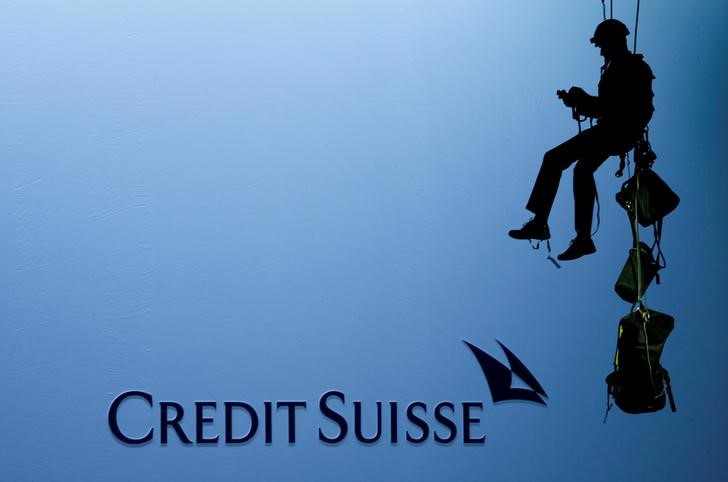 © Reuters. An activist of environmental group Greenpeace is seen beside the logo of of Swiss bank Credit Suisse in Zurich