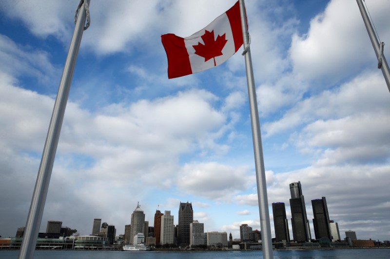 © Reuters. A Canadian flag flutters in front of the Detroit skyline, dominated by General Motors headquarters (R), is seen from Windsor, Onatario