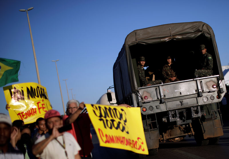 © Reuters. Caminhão do Exército passa por pessoas apoiando caminhoneiros em greve em Luziânia, no Brasil