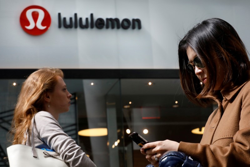 © Reuters. FILE PHOTO: People walk past a store by yogawear retailer Lululemon Athletica in New York