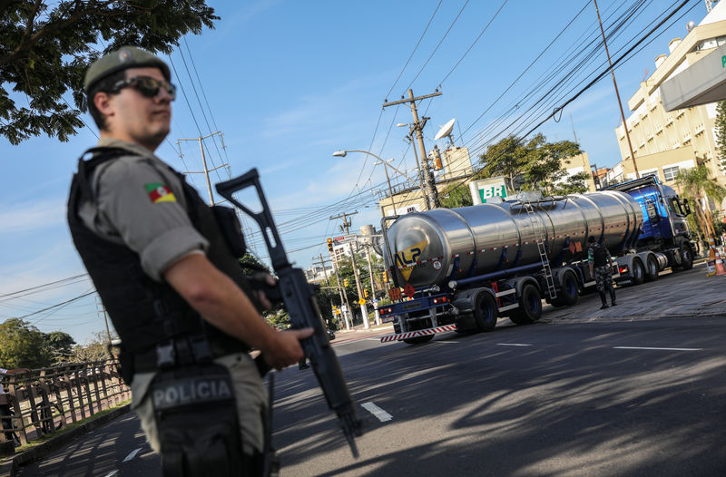 © Reuters. Policial se posiciona enquanto caminhão-tanque chega a posto em Porto Alegre