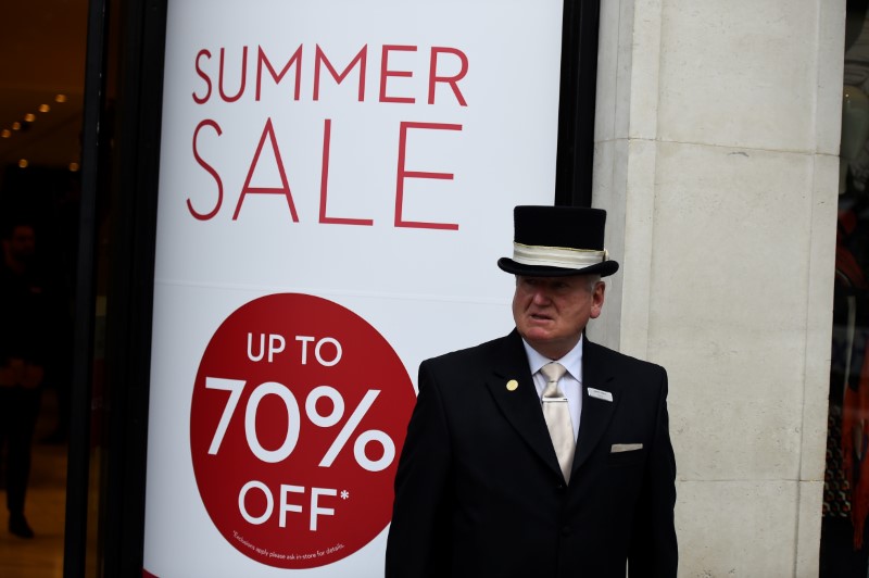 © Reuters. FILE PHOTO: A concierge stands outside a shop that is having a summer sale in Dublin