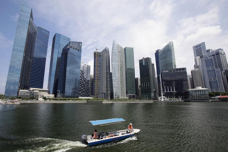 © Reuters. Boat manoeuvres in front of skyscrapers of Marina Bay Financial Centre in Singapore