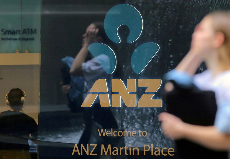 © Reuters. FILE PHOTO: A pedestrian is reflected in the window of a branch of the Australia and New Zealand Banking Group (ANZ) in central Sydney