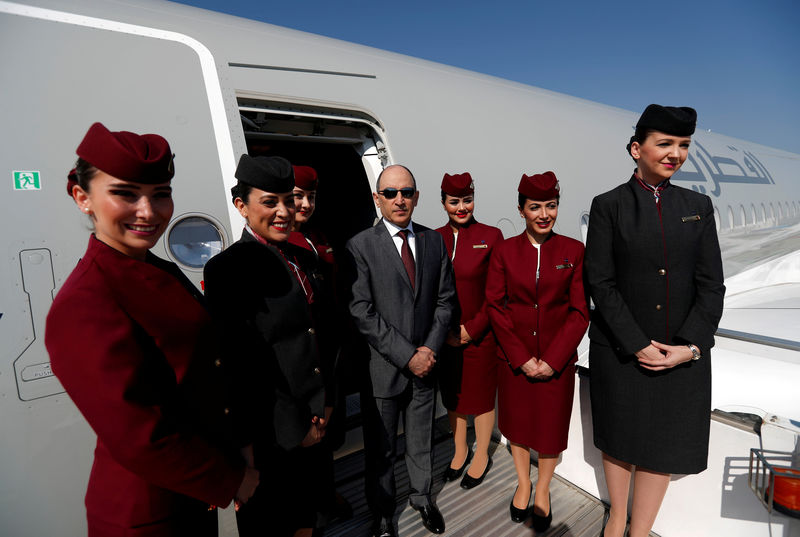 © Reuters. FILE PHOTO: Qatar Airways Chief Executive Officer Akbar al-Baker poses with cabin crew in an Airbus A350-1000 at the Eurasia Airshow in the Mediterranean resort city of Antalya