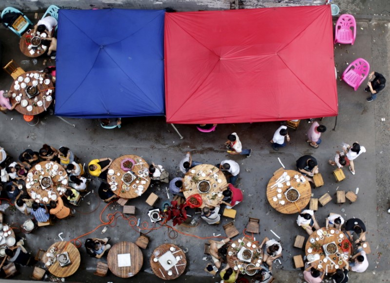 © Reuters. Pessoas fazem refeição em festival gastronômico em Yulin, na China