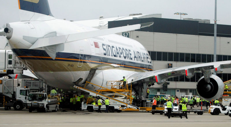 © Reuters. FILE PHOTO: Airport workers crowd around the first scheduled commercial flight of an Airbus A380 after it landed in Sydney