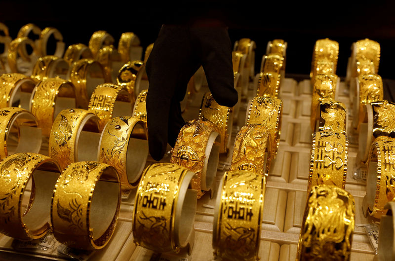 © Reuters. FILE PHOTO: A salesperson arranges 24K gold bracelets for Chinese weddings at Chow Tai Fook Jewellery store in Hong Kong