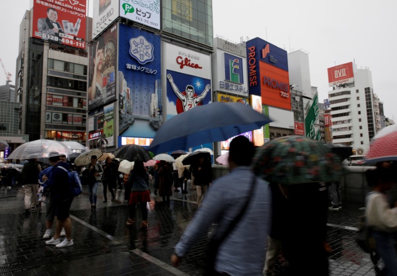 © Reuters. FILE PHOTO: Commuters walk under umbrellas in Osaka