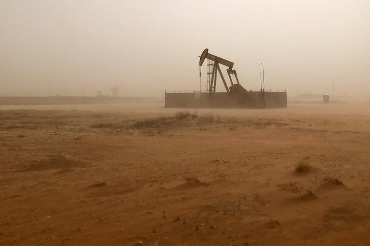 © Reuters. FILE PHOTO: Pump jack lifts oil out of well during sandstorm in Midland