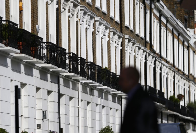 © Reuters. A man walks past a row of houses in Chelsea in London