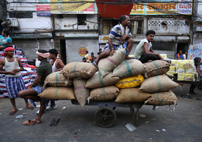 © Reuters. Labourers rest on a handcart loaded with spices in a market area in the old quarters of Delhi