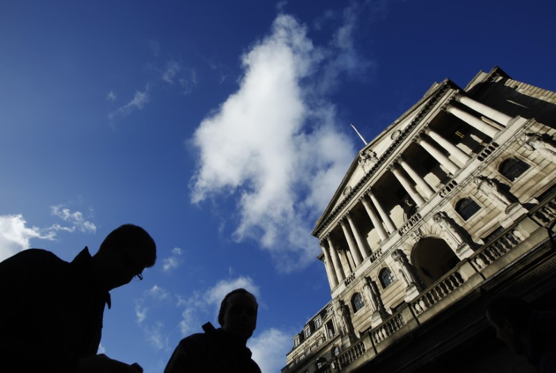 © Reuters. FILE PHOTO: People pass the Bank of England in the City of London