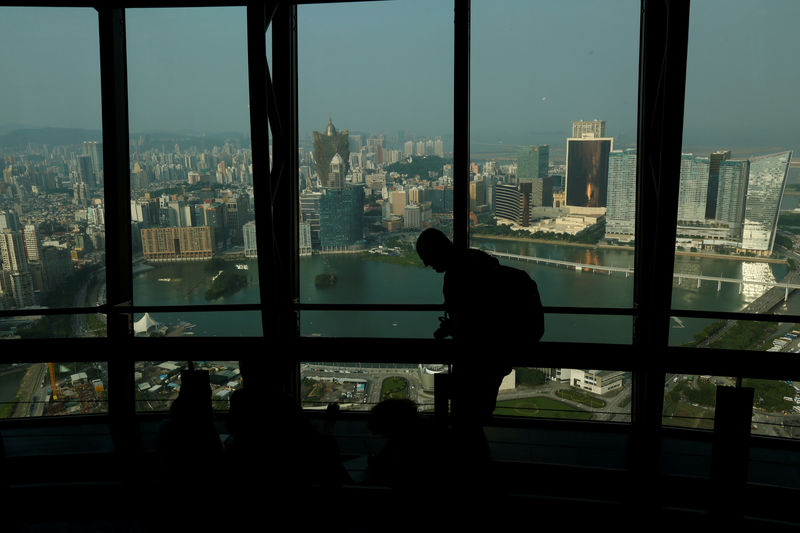 © Reuters. FILE PHOTO - A visitor walks inside Macau Tower overlooking a general view of Macau peninsula