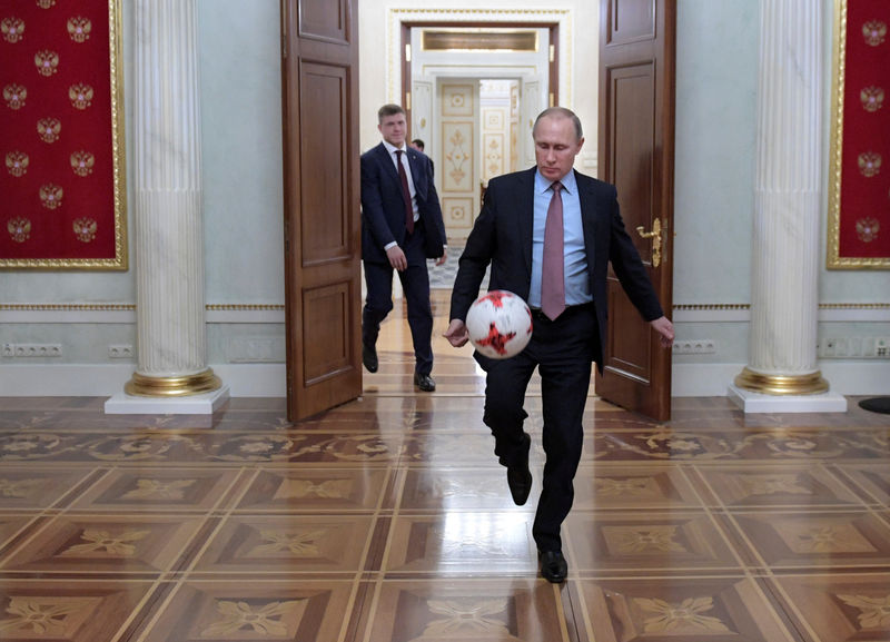 © Reuters. Russian President Putin plays with a ball following a meeting with FIFA President Gianni Infantino at the Kremlin in Moscow