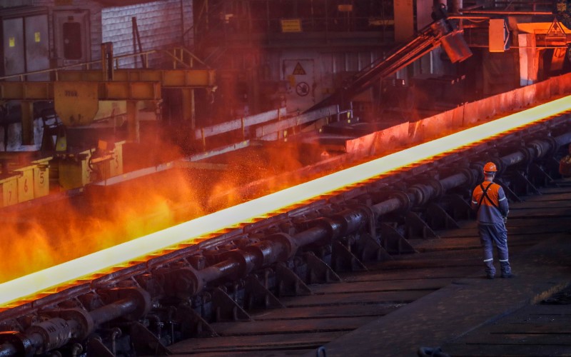 © Reuters. FILE PHOTO: A red-hot steel plate passes through a press at the ArcelorMittal steel plant in Ghent