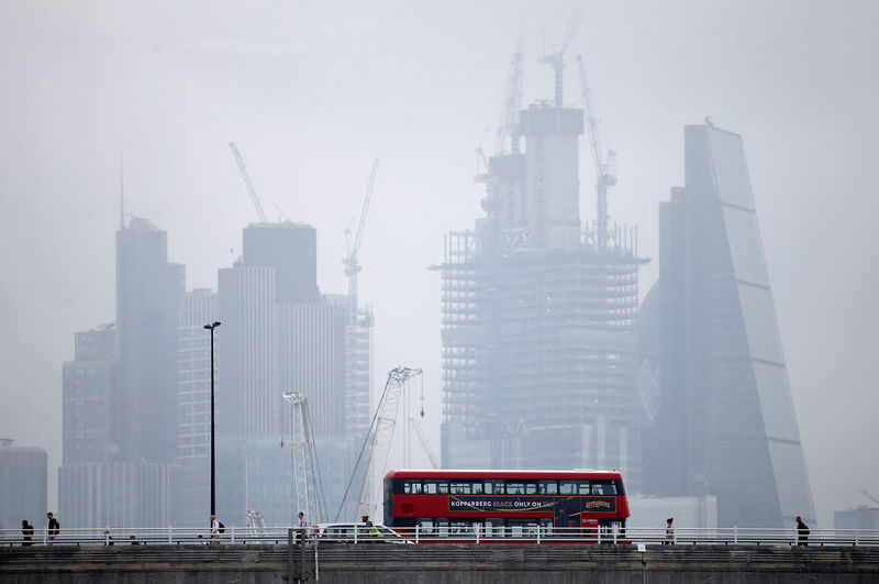 © Reuters. A traditional red London bus crosses Waterloo Bridge, with the financial district in the background, in London