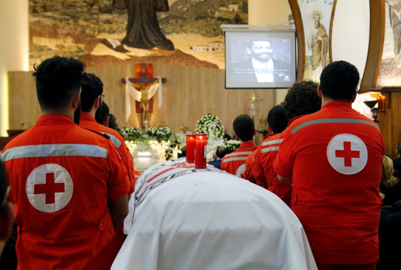 © Reuters. Membros da Cruz Vermelha libanesa ao lado do caixão de membro da entidade morto no Iêmen