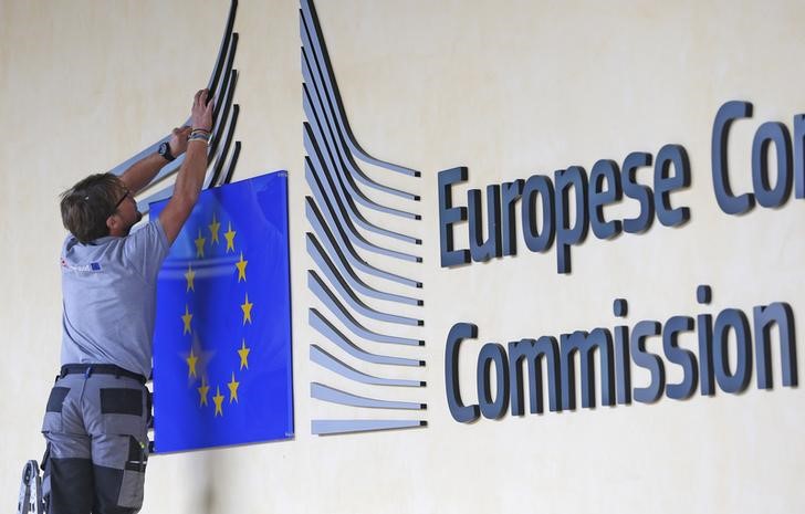 © Reuters. A worker adjusts and cleans the logo of the European Commission at the entrance of the EC headquarters in Brussels