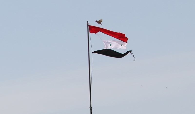 © Reuters. Bandeira rasgada da Síria é vista na cidade de Qamishli