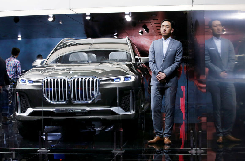 © Reuters. FILE PHOTO: A model stands next to a BMW X7 concept car at the Auto China 2018 motor show in Beijing