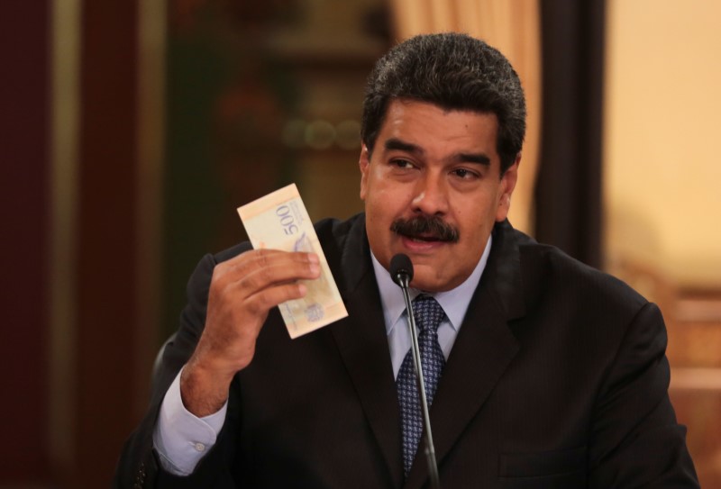 © Reuters. El presidente venezolano Nicolás Maduro muestra un nuevo billete de 500 bolívares soberanos durante una reunión con ministros en el Palacio de Miraflores en Caracas.