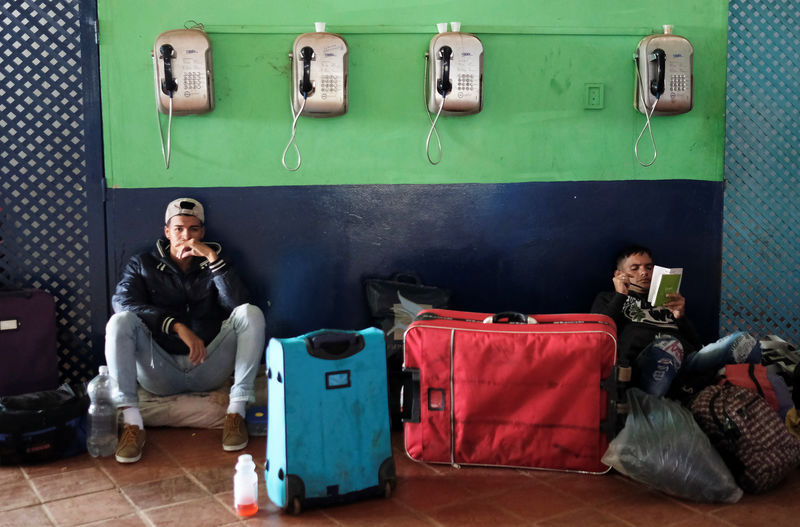 © Reuters. Migrantes descansan junto a sus pertenencias en un terminal de buses en Santa Elena, Venezuela, tras ser expulsados de Pacaraima en Brasil.