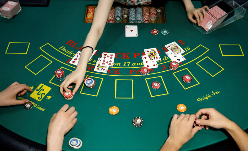 © Reuters. Students practice on a black jack table at Japan Casino School in Tokyo