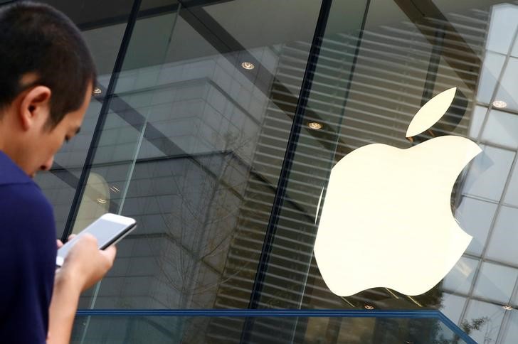 © Reuters. Pessoa utiliza celular diante de loja da Apple em Pequim, China