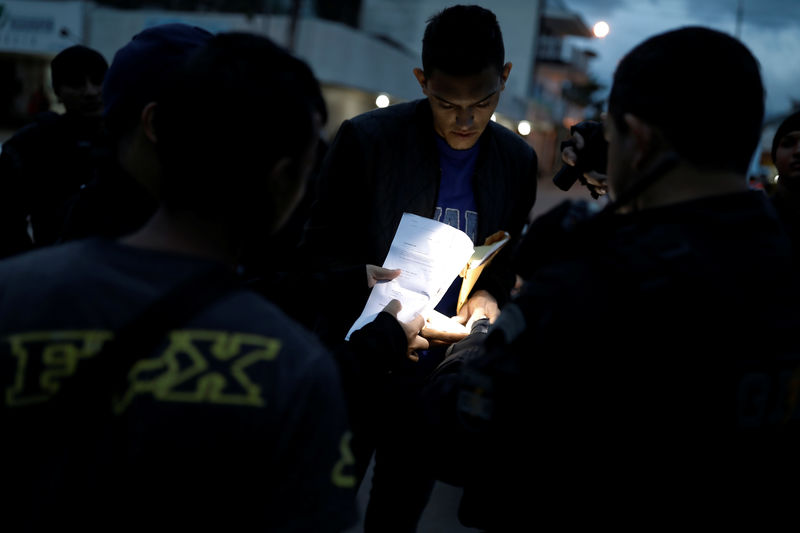 © Reuters. Venezuelano apresenta documentação para policiais em Pacaráima, Roraima
