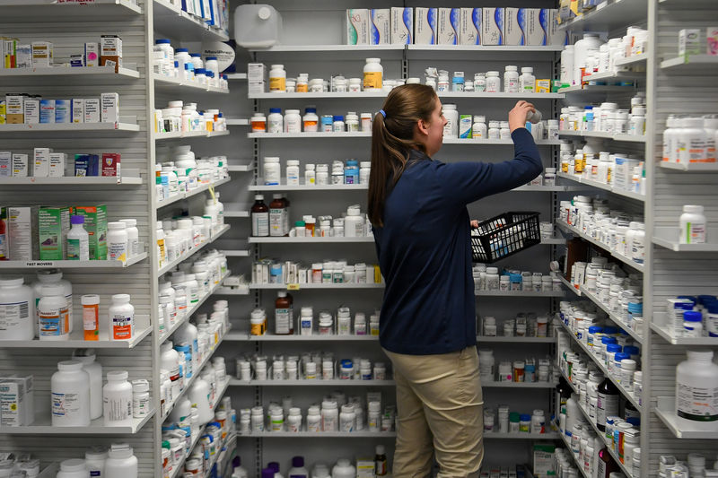 © Reuters. FILE PHOTO - A technician stocks the shelves of the pharmacy at White House Clinic in Berea