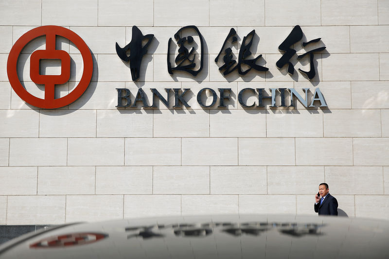 © Reuters. FILE PHOTO: A man speaks on the phone outside the Bank of China head office building in Beijing