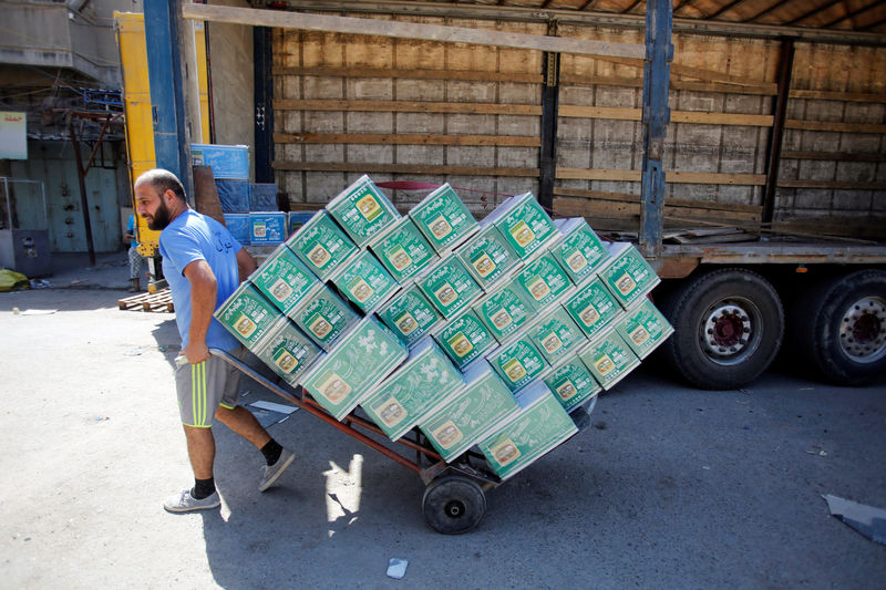 © Reuters. Iraqi workers unload a truck from Iran, loaded with cosmetics, in Baghdad