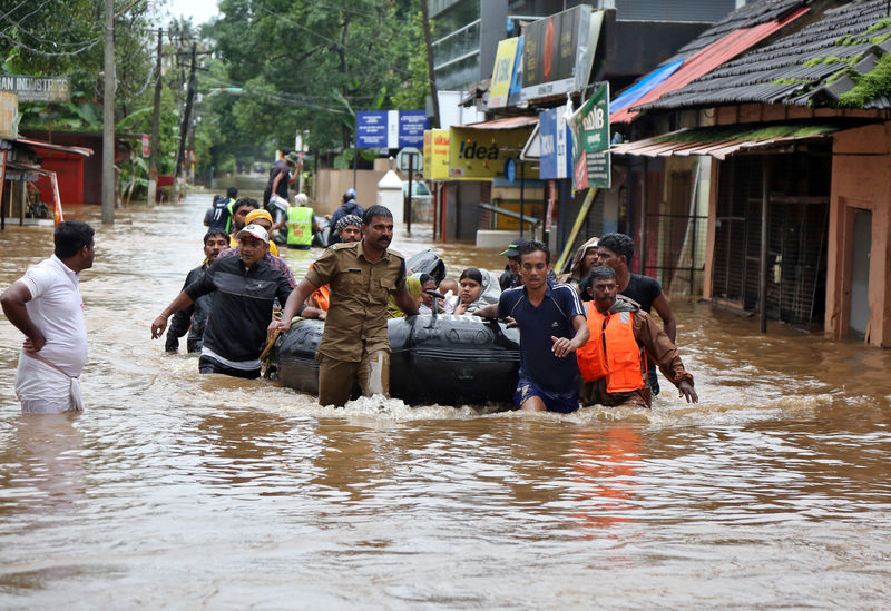 © Reuters. Rescuers evacuate people from a flooded area to a safer place in Aluva