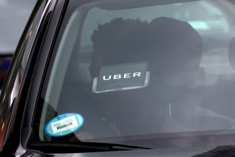 © Reuters. FILE PHOTO:    An Uber logo is seen on a car a as it car drives through Times Square in New York City