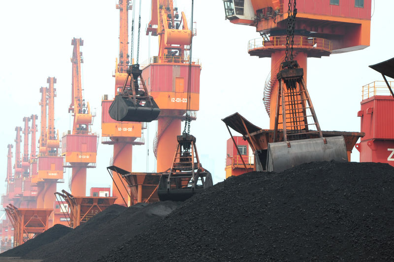 © Reuters. Imported coal is seen lifted by cranes from a coal cargo ship at a port in Lianyungang, Jiangsu