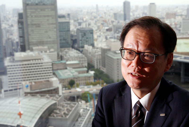 © Reuters. Mizuho Financial Group's CEO Tatsufumi Sakai attends an interview with Reuters as Bank of Japan buildings are seen at the company's headquarters in Tokyo