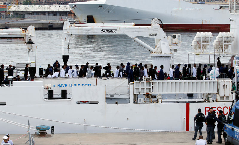 © Reuters. Migrants waits to disembark from Italian coast guard vessel "Diciotti" as they arrive at the port of Catania